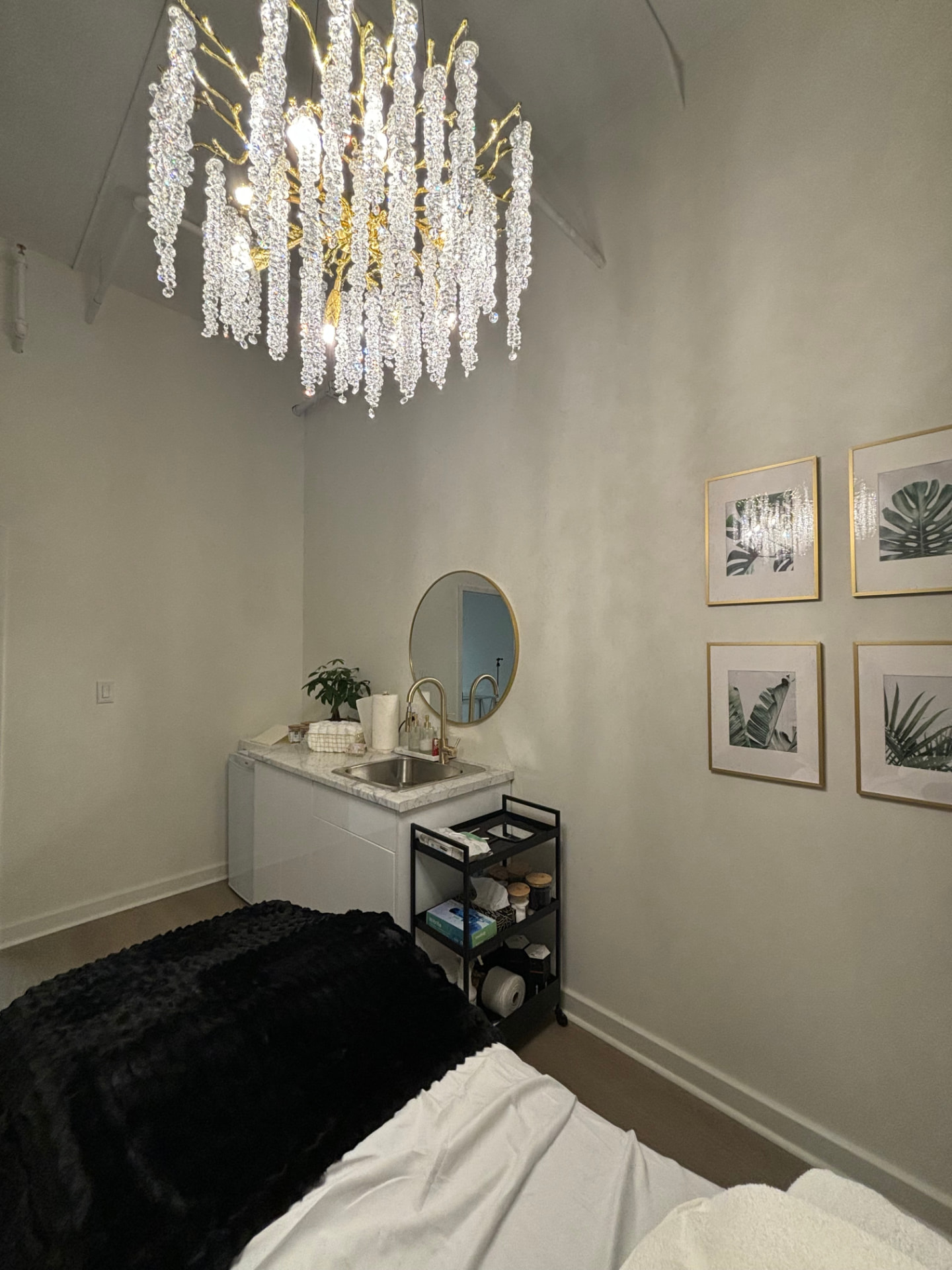 Corner of the Garden Suite with marble-top vanity, sink, round gold mirror and gallery wall