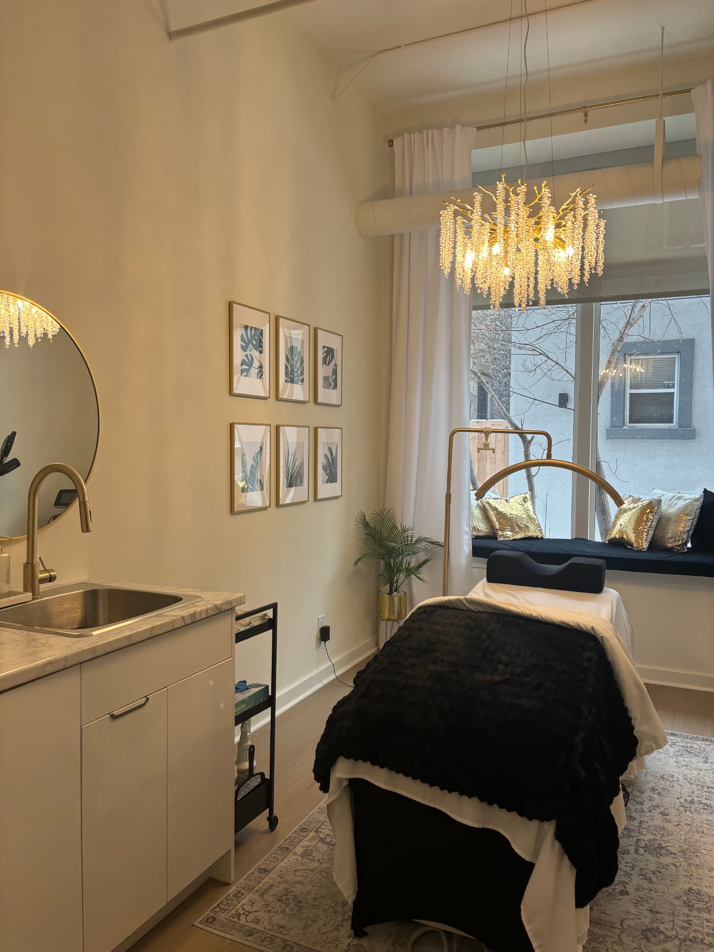 The Garden Suite staged with a treatment bed, crystal chandelier and a window bench